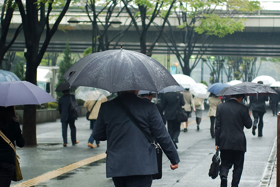 傘をさして歩いている通勤の風景